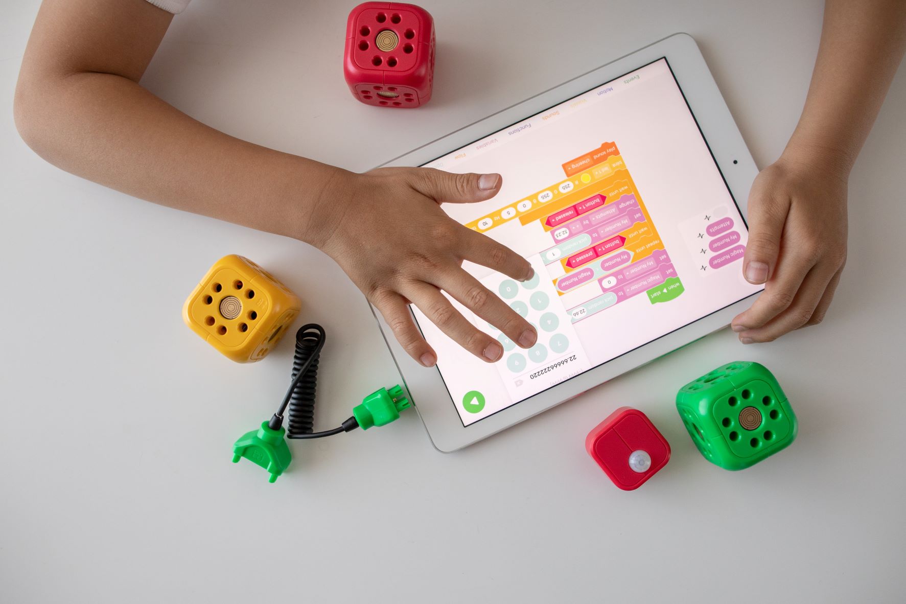 Cubes and tablet where child is using calculator