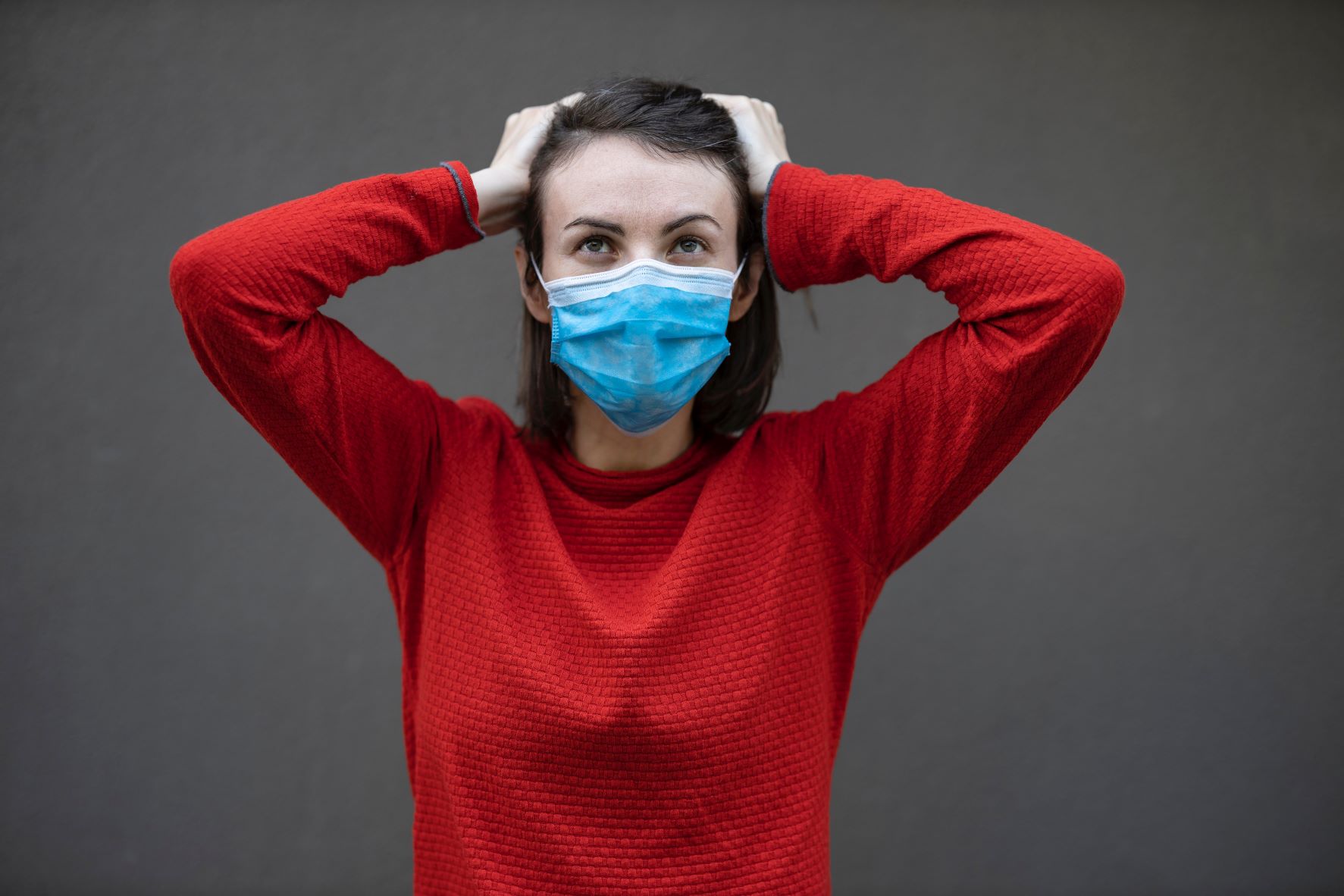 Lady wearing her mask with hands in her hair looking flustered